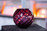 Violet Marika Vase on a wooden surface with the reflections of the flames from our ovens